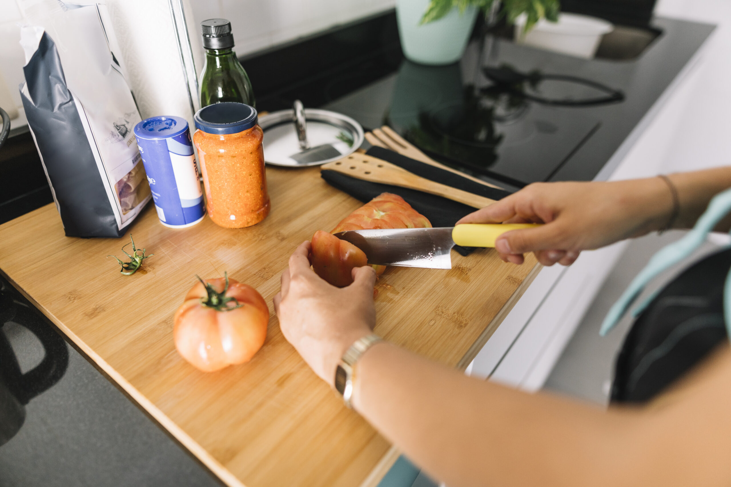 woman s hand cutting slices tomato with knife kitchen counter scaled TheHomeQuality
