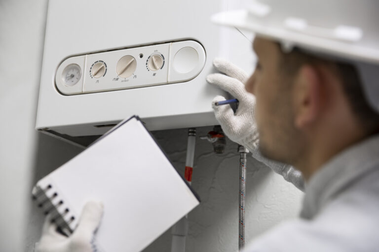 worker repairing water heater TheHomeQuality